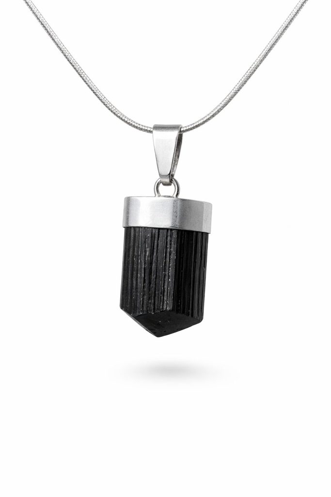 Prisma negro estriado a lo largo, rematado por un capuchón cilíndrico de plata, colgado de una cadena fina