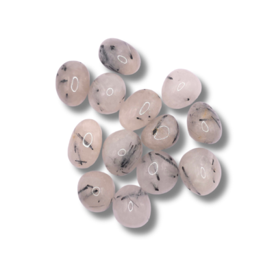 Rodados de cuarzo blanco lechoso atravesados por agujas y trazos negros de turmalina, cortos y dispersos.